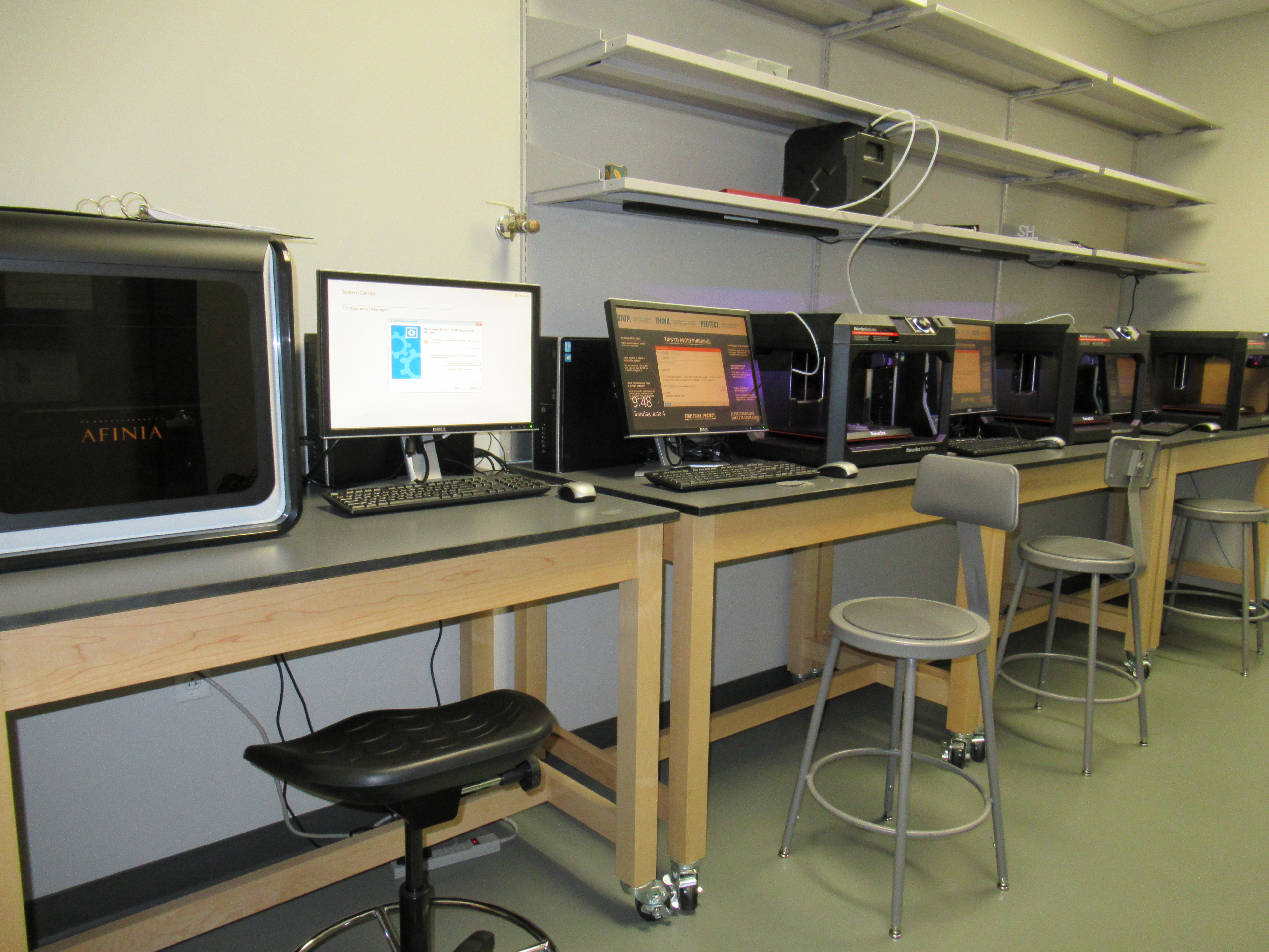 row of computers with a 3d printer at the end