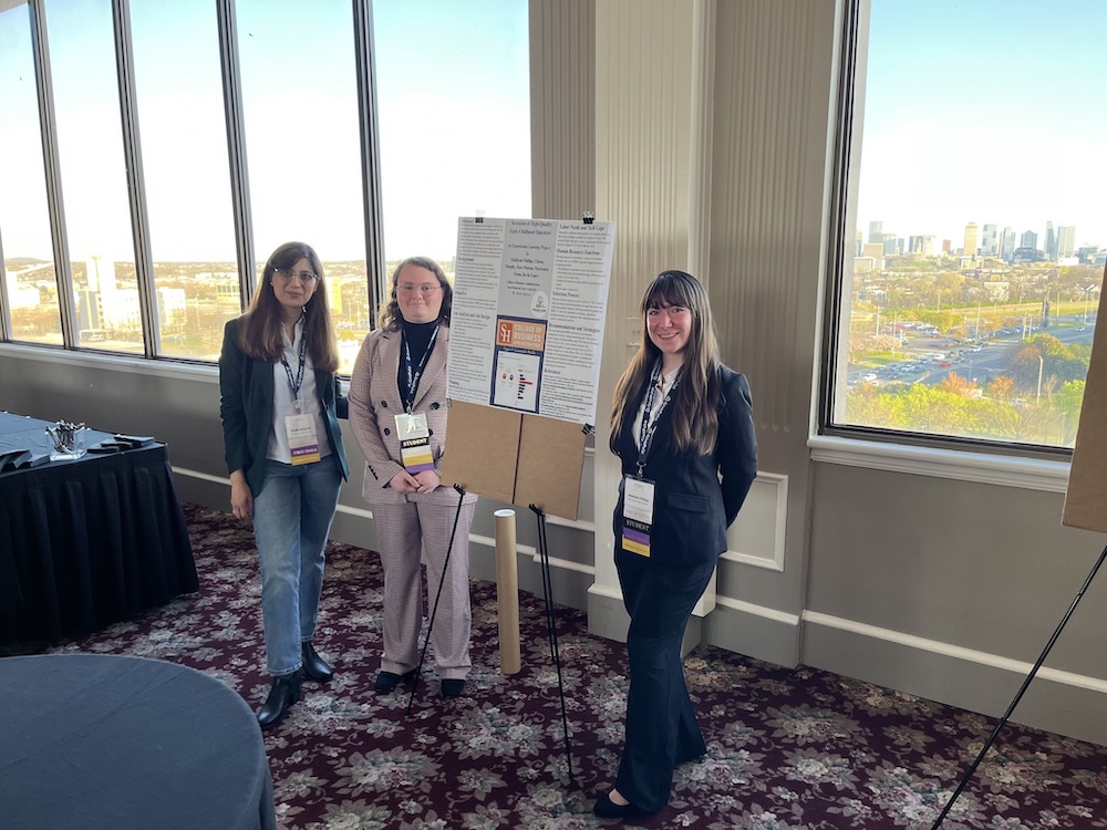 Sam Houston State students Madilynn Phillips and Sara Mortus pose with COBA professor Huda Masood and a poster presentation on their ACE course findings. Masood's ACE course, which focused on human resource management for a local non-profit, was one of two highlighted in a recent publication of COBA's Journal of Business Strategies.